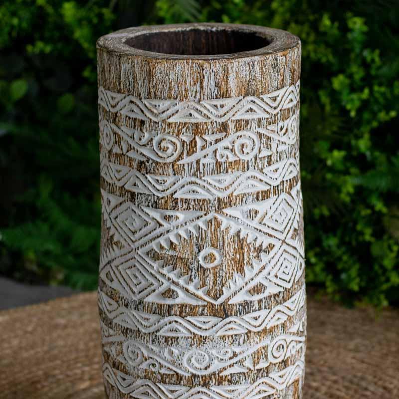 Vista de ângulo de vaso rústico de Timor posicionado sobre tapete de fibra natural, criando um ambiente orgânico e acolhedor.