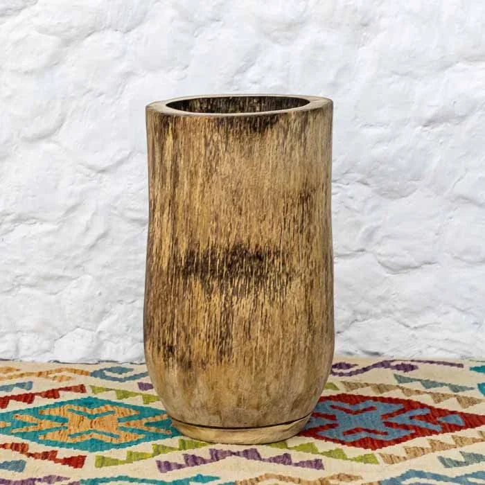 Vaso orgânico cilíndrico feito de tronco de palmeira natural sob fundo claro.