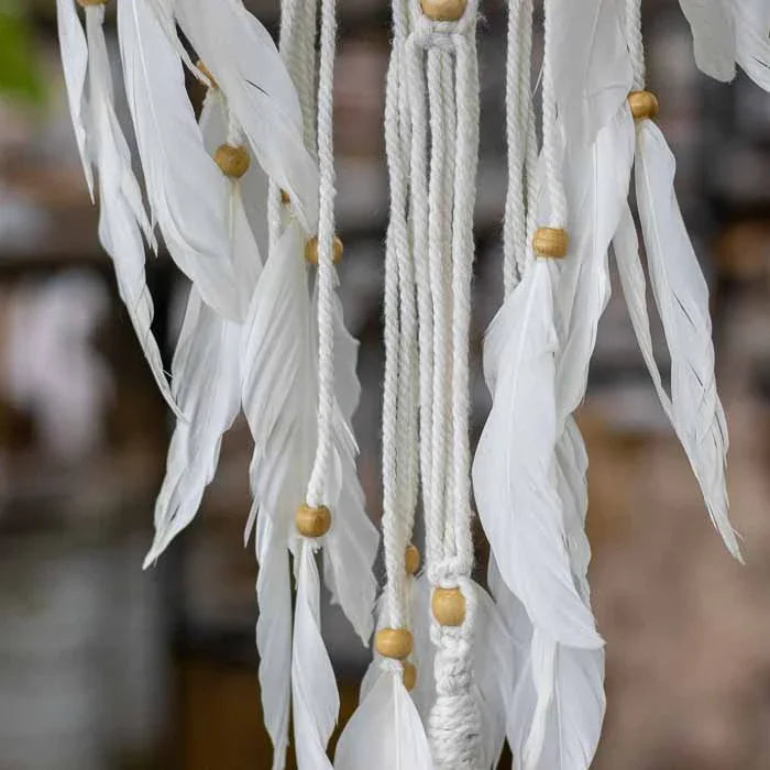 Filtro dos sonhos em macramê artesanal de Bali com penas brancas.