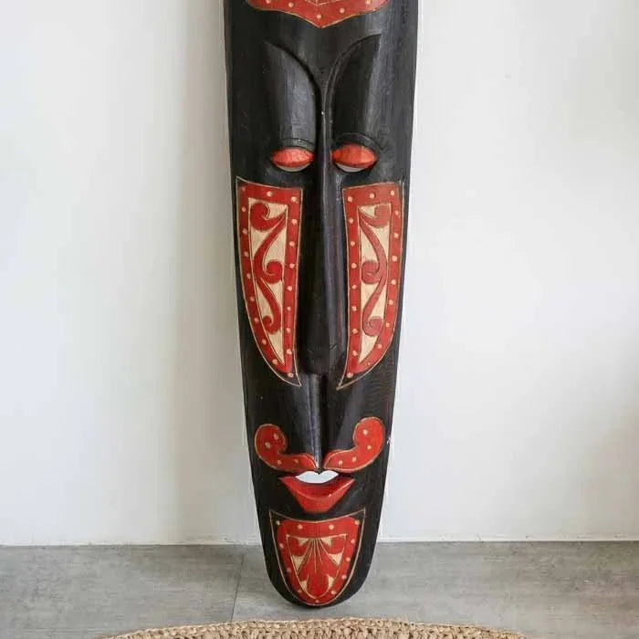 Máscara tribal entalhada em madeira escura artesanal de Lombok.