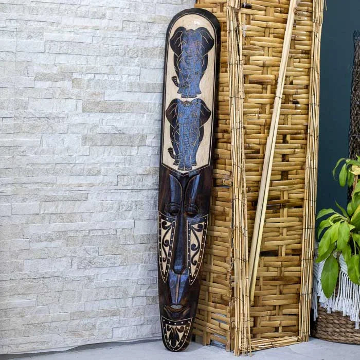 Arte de Lombok com símbolo de proteção esculpido em madeira artesanal.