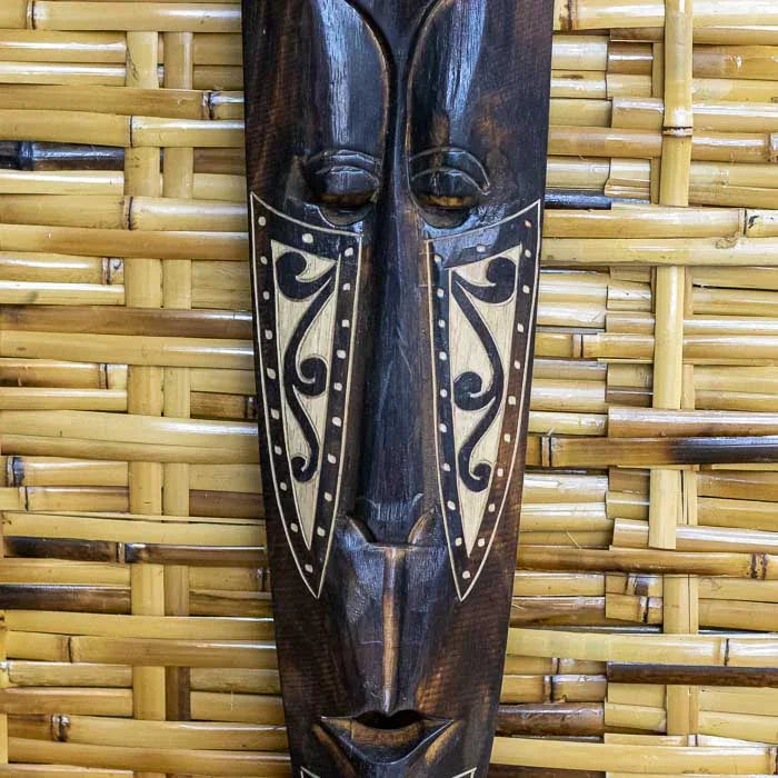 Máscara decorativa em madeira com imagem de elefante e traços culturais.