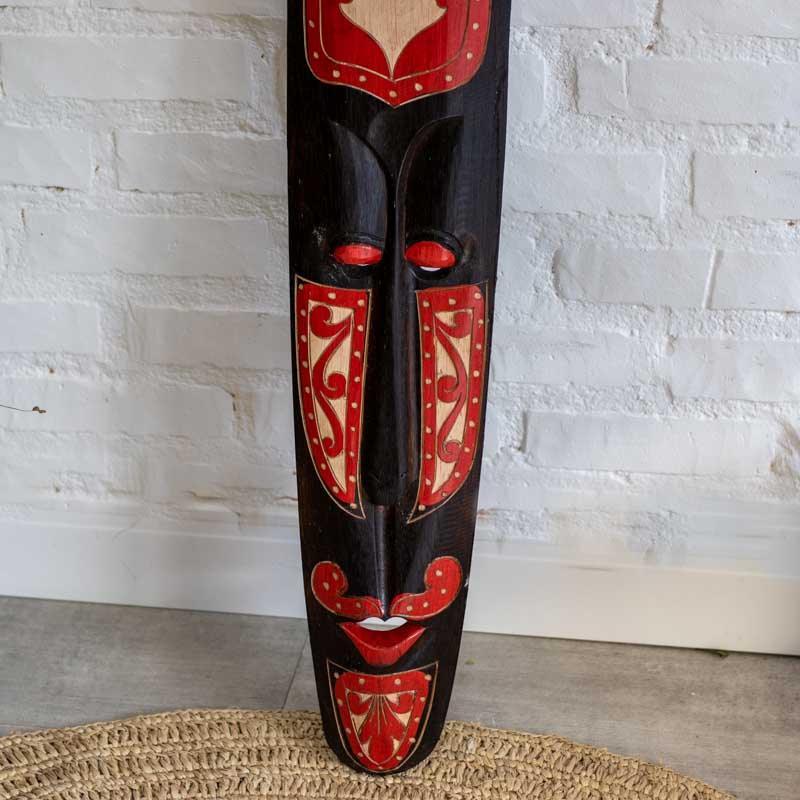 Máscara tribal entalhada em madeira escura artesanal de Lombok.