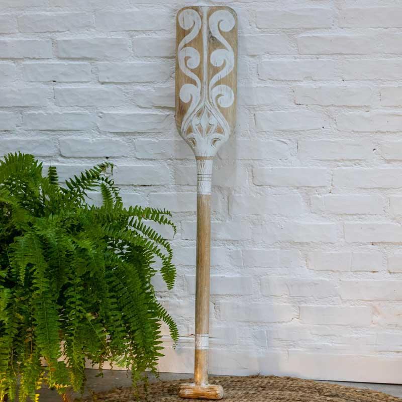 Detalhe dos entalhes em relevo na pá de remo decorativo artesanal com acabamento em pátina branca.