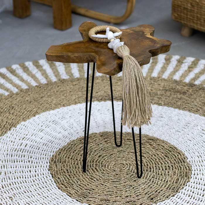 Peça artesanal de madeira teca com forma irregular e pés de ferro usada como mesa de apoio sofisticada em Home Decor.