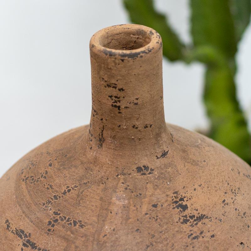 Detalhe da superfície rugosa de um vaso de cerâmica manual, destacando as variações naturais da argila e o acabamento rústico exclusivo.