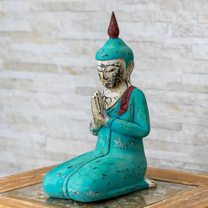 Estátua de Buda com pátina em tons de turquesa e vermelho (acabamento desgastado).
