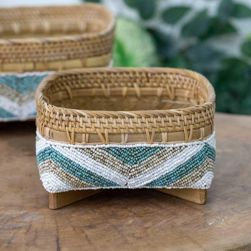 Cestaria decorativa balinesa com miçangas azuis e brancas, uma peça que une funcionalidade e arte étnica para o lar.