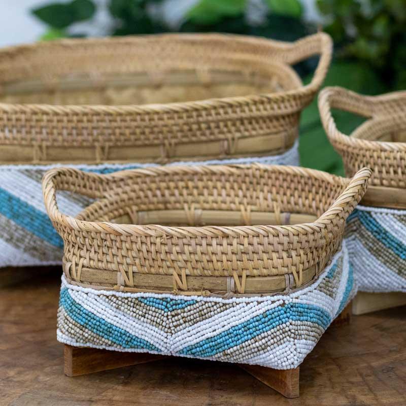 Cestaria de bambu com alças integradas e pequenos pés de madeira, mostrando a textura rústica e o trabalho artesanal fino.