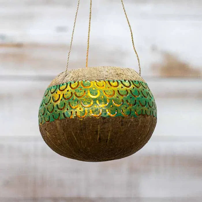 Detalhe da curvatura natural da casca do coco em lanterna suspensa artesanal.