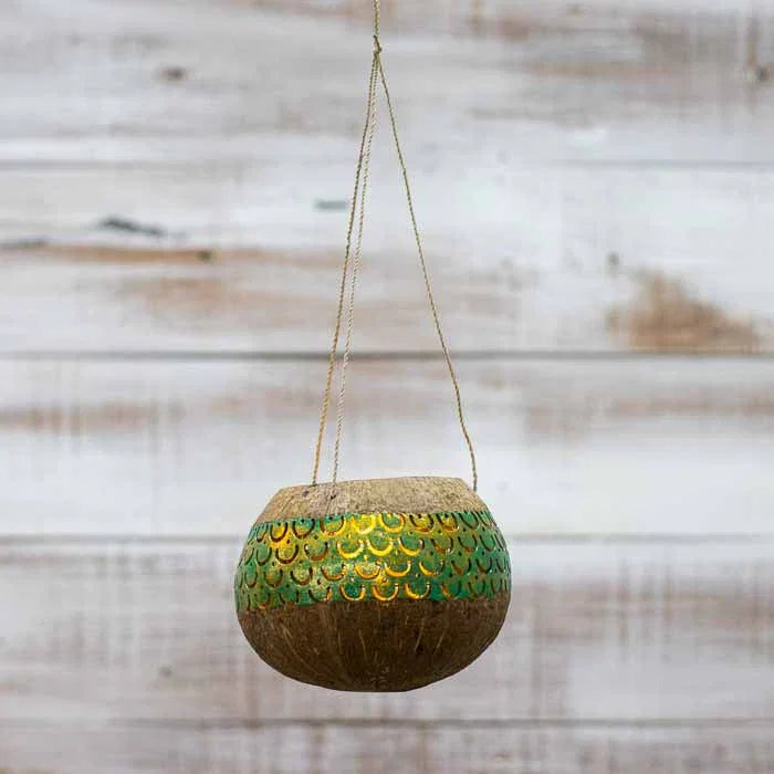 Porta-vela de coco com acabamento manual e cordão resistente para pendurar.