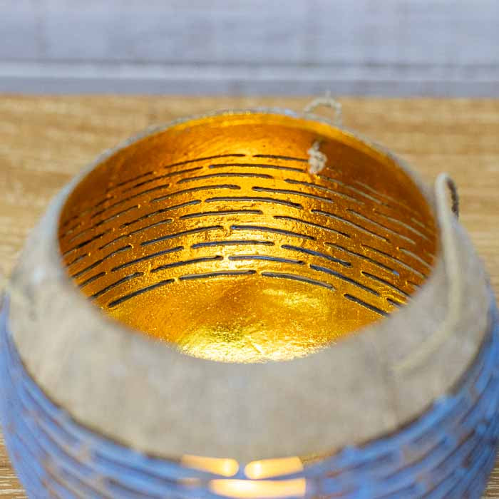 Detalhe de lanterna suspensa de coco balinesa com entalhes manuais artísticos.