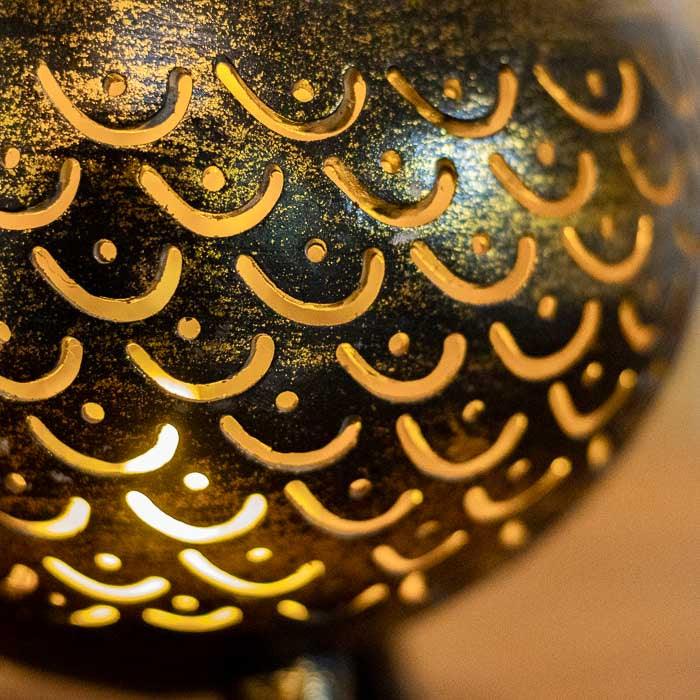 Peça em coco natural com cortes manuais para efeito de luz artística.