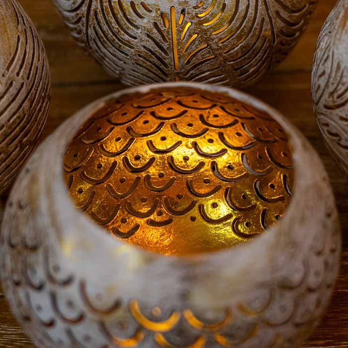 Porta-vela artesanal balinês em coco natural com suporte de três pés fixos.