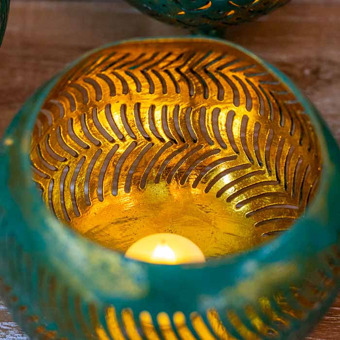 Porta-vela rústico com pés de madeira, ideal para iluminação suave em áreas de descanso.