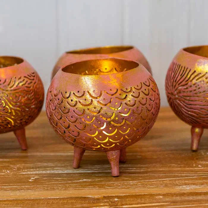 Porta-vela artesanal feito de casca de coco natural com pés fixos de madeira.