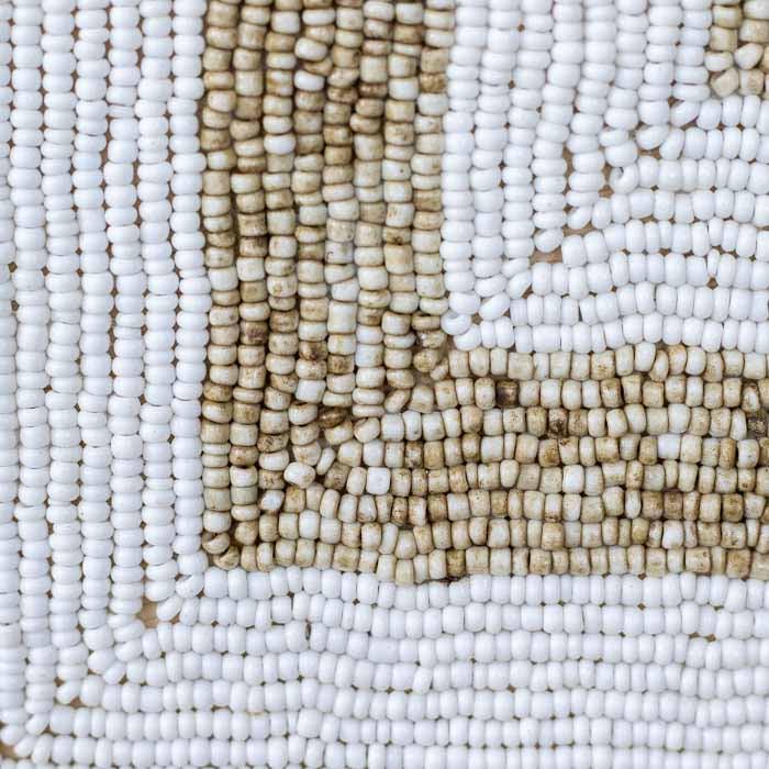 Mandala artesanal redonda feita à mão em Bali com conchas brancas naturais aplicadas em padrão simétrico.