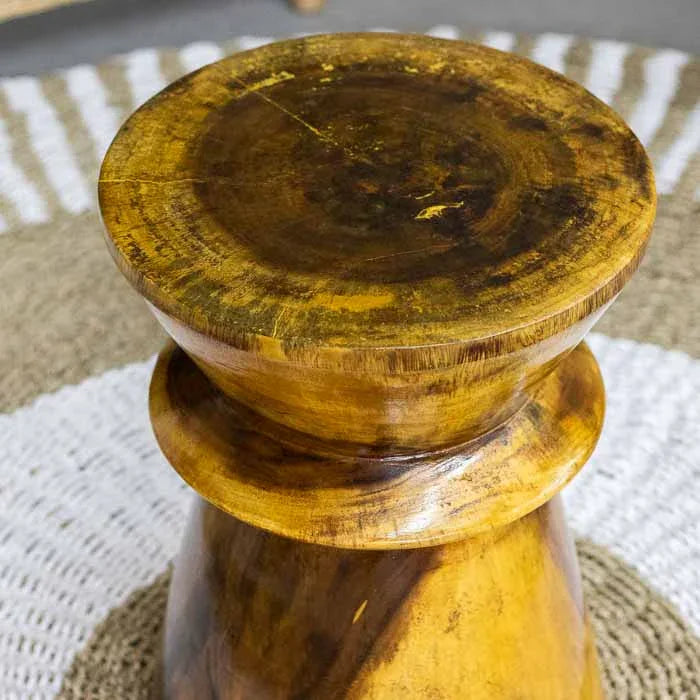 Banco de apoio artesanal com traços tribais, ideal para ambientes com estética natural.