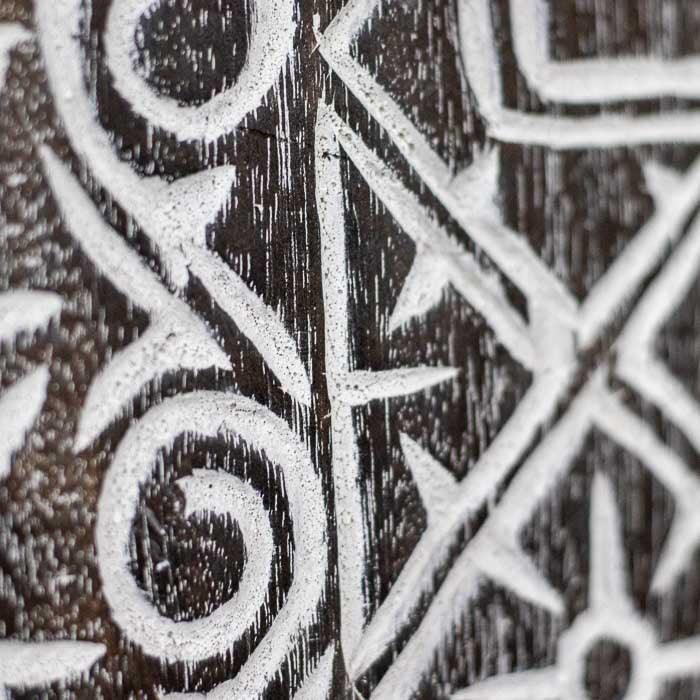 Painel balinês inspirado em Timor, com entalhes marcantes e acabamento rústico.