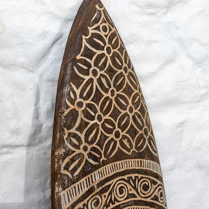 Arte decorativa timorense feita à mão em madeira com entalhes geométricos e acabamento rústico, ideal para compor espaços com estilo étnico e natural.