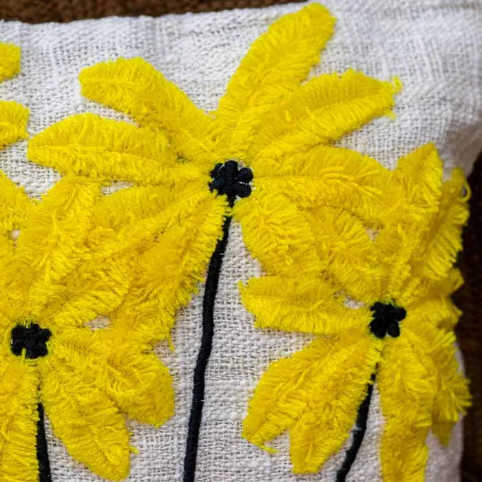 Detalhe da textura macia do bordado artesanal amarelo em almofada de Bali.