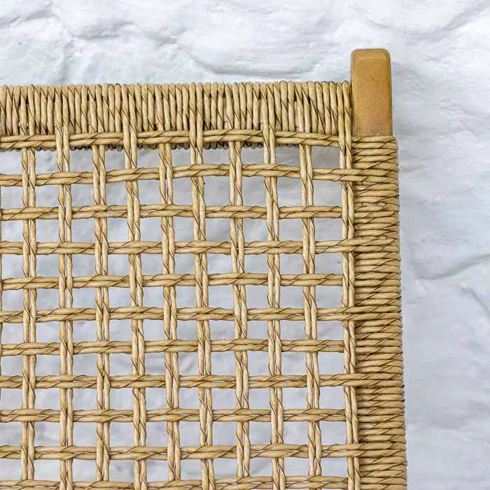 Cadeira de relaxamento estilo litorâneo com assento em trama de palha natural.