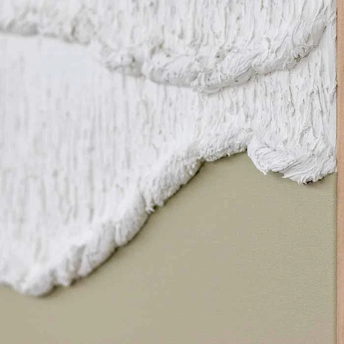 Detalhe da textura em massa criando movimento de ondas em tela decorativa.