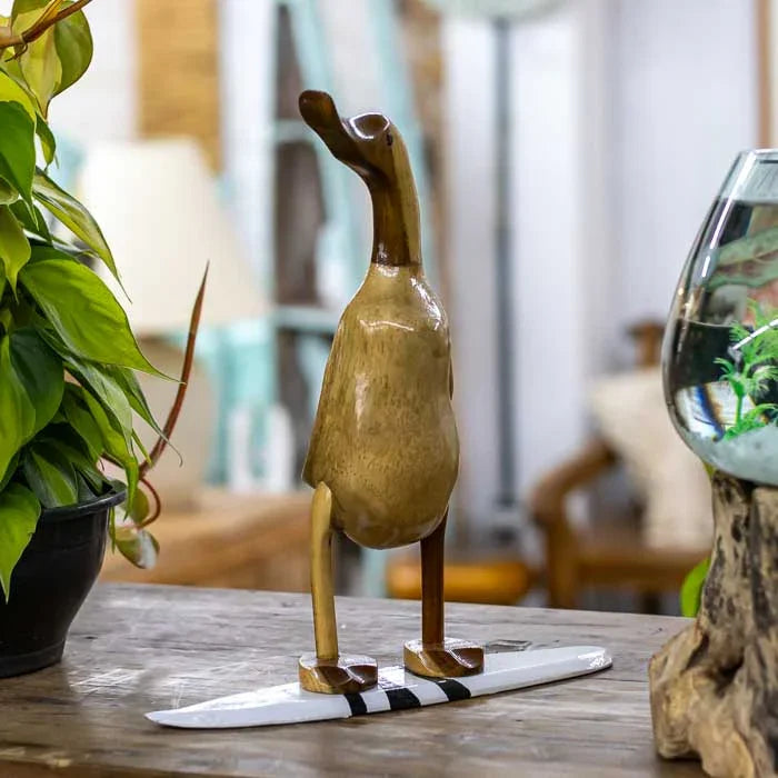 Pato surfista decorativo com prancha branca e listras pretas de Bali