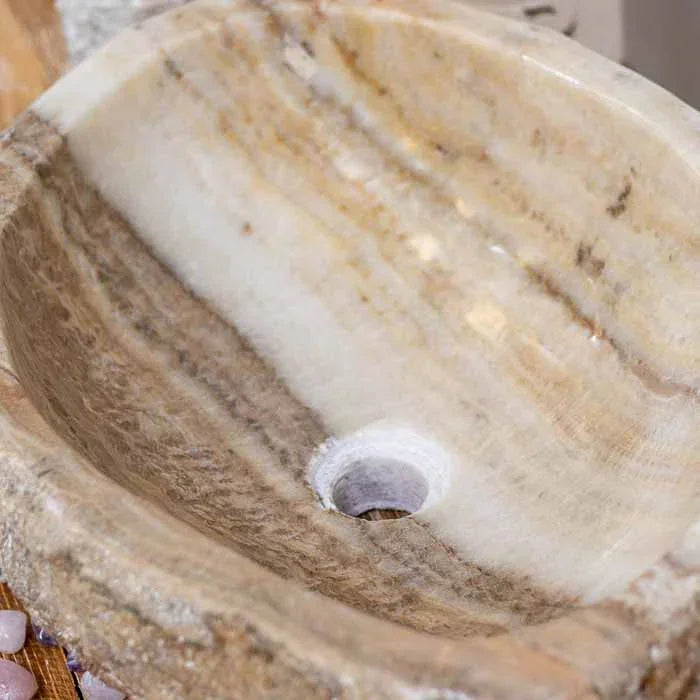 Pia de pedra balinesa, com formato oval e alto valor de exclusividade e design.