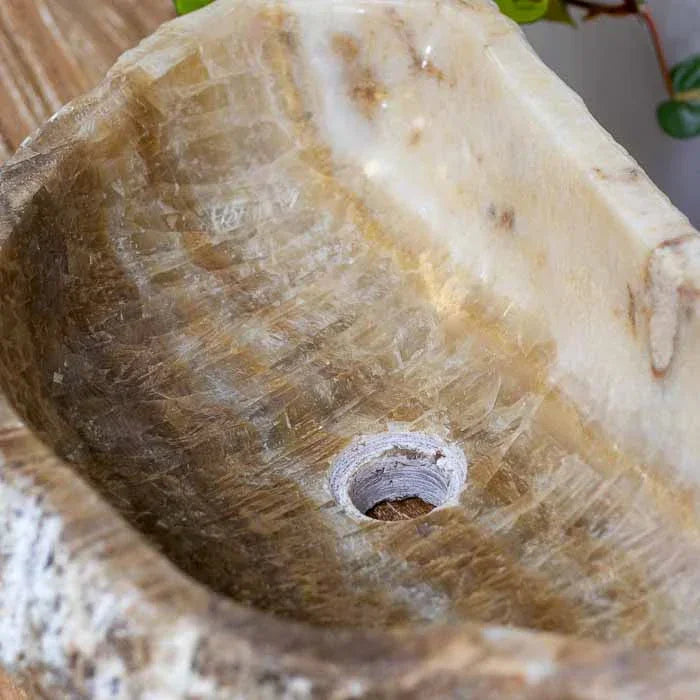 Cuba de pia esculpida manualmente, evidenciando os veios únicos da pedra.