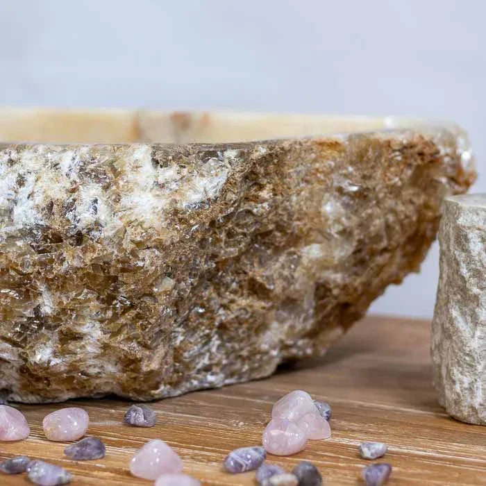 Decoração premium: cuba de pedra natural sobre bancada de madeira, com pedras de quartzo.