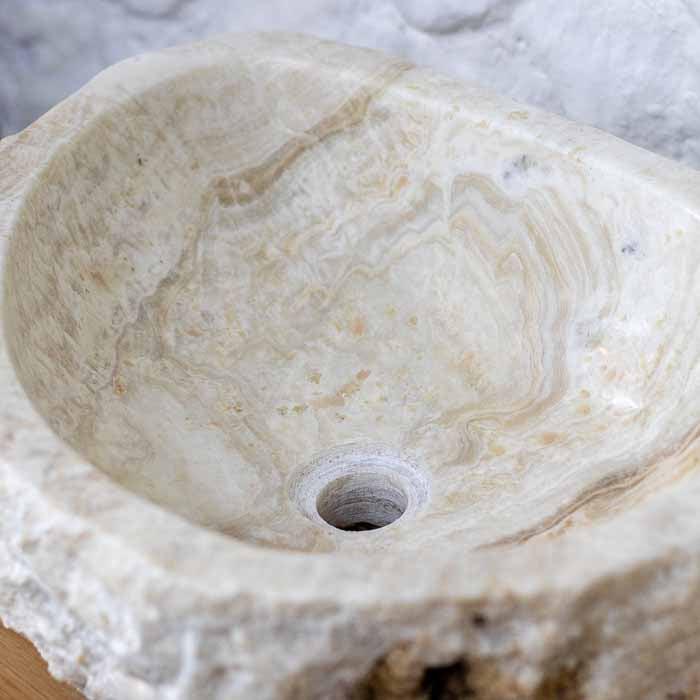 Decoração premium: cuba de pedra natural sobre bancada de madeira, com pedras de quartzo.