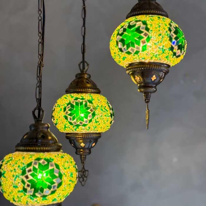 Luminária de teto turca com três cúpulas redondas em mosaico de vidro colorido e estrutura de metal bronzeada.