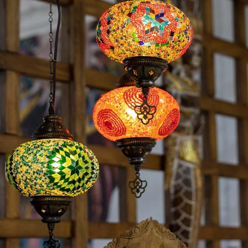 Iluminação decorativa de luxo rústico com pendente turco artesanal, integrando metal envelhecido e arte em vidro.