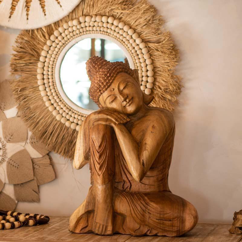 Estátua de Buda relaxando com a cabeça no joelho esculpida em madeira maciça de Bali.