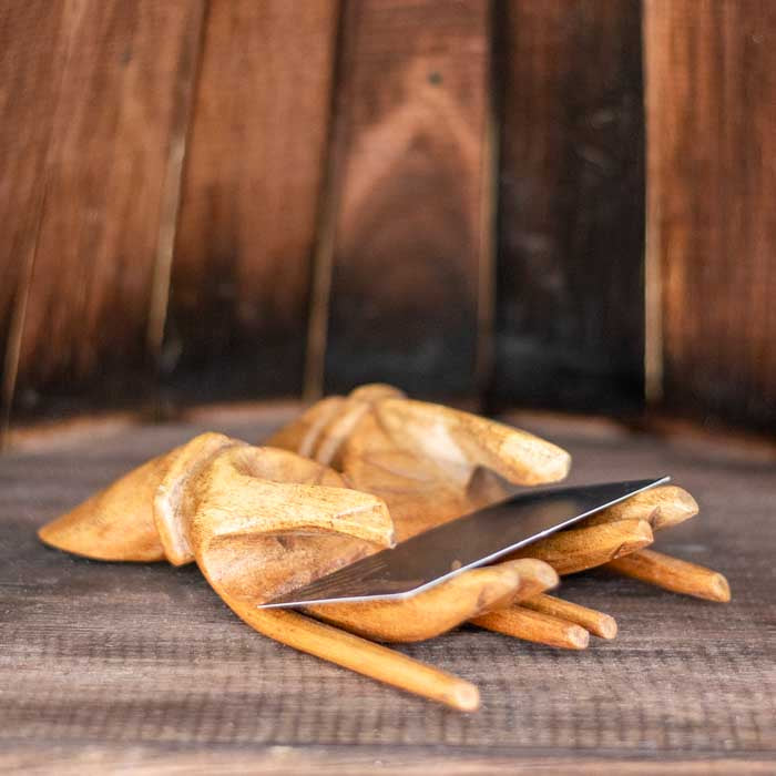 Peça artesanal em madeira com design de mãos unidas para cartões.