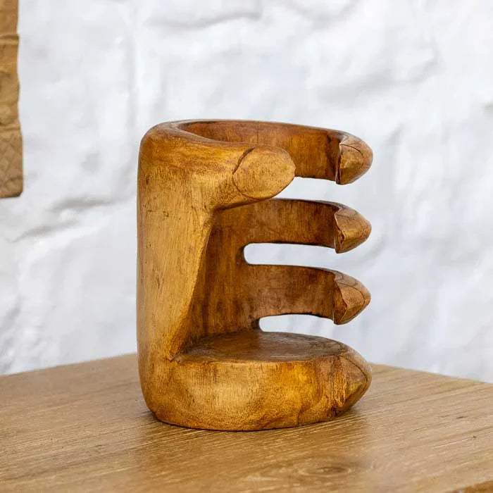 Escultura utilitária de madeira em formato de mão feita por artesãos balineses.