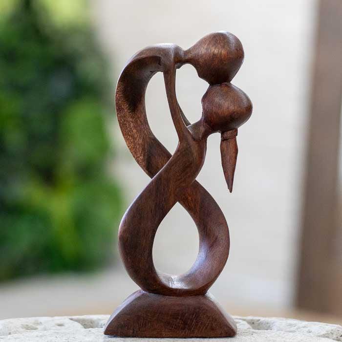 Escultura de madeira suar feita à mão em Bali com forma de amor infinito.