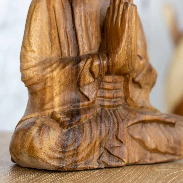 Detalhe da escultura de Buda com expressão serena e acabamento natural.