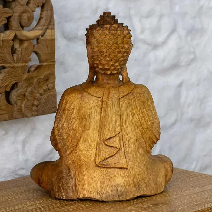 Escultura artesanal de madeira simbolizando paz e iluminação espiritual.