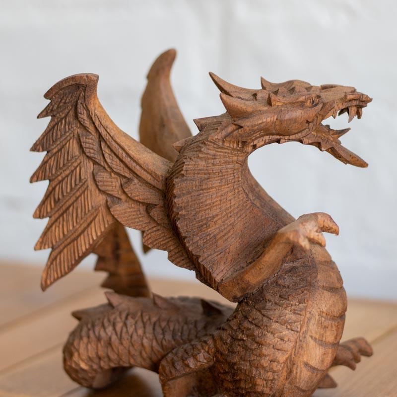 Dragão alado de 100cm em madeira maciça posicionado como peça central de decoração.