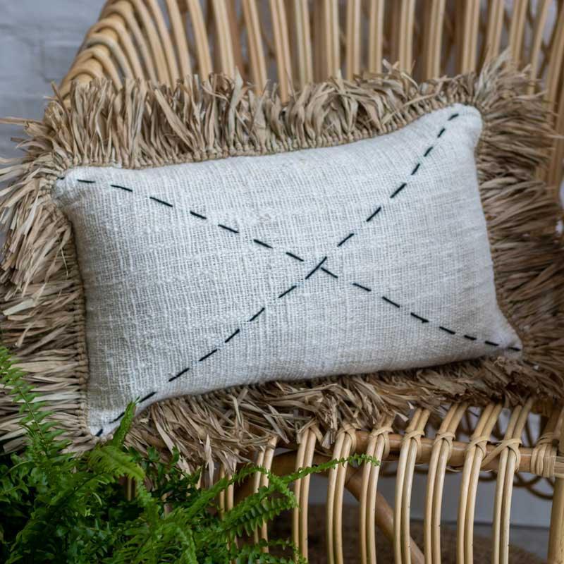 Almofada boho em fibra natural artesanal com bordado de traços.