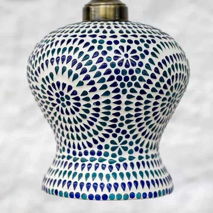 Cúpula pendente de mosaico claro com rosetas em tom azul e borda inferior decorada.