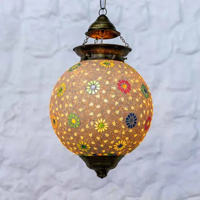 Detalhe da cúpula redonda de vidro em mosaico com acabamentos metálicos envelhecidos na base e no topo.