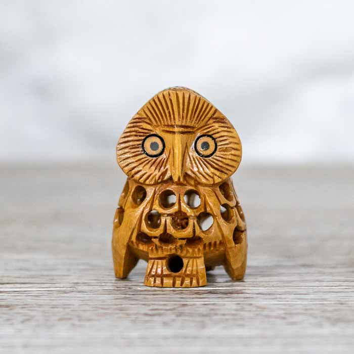 Mini escultura de coruja indiana com detalhes nos olhos e asas entalhadas.