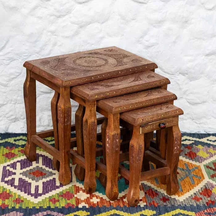 Mesa de apoio em madeira entalhada à mão com detalhes de mandala e apliques metálicos.