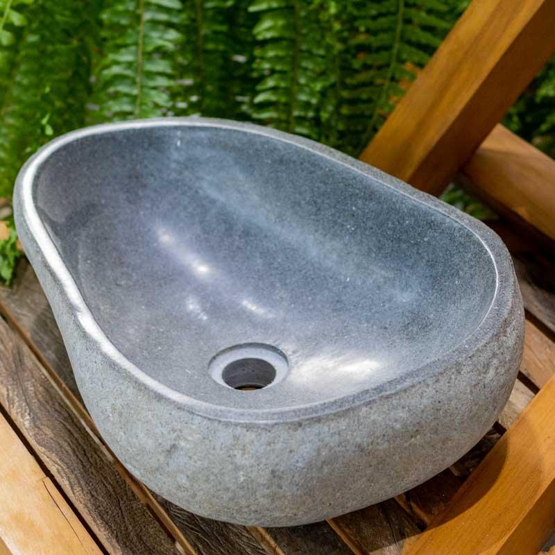 Cuba de pedra natural para lavabo de alto padrão com acabamento interno liso e bordas irregulares naturais.