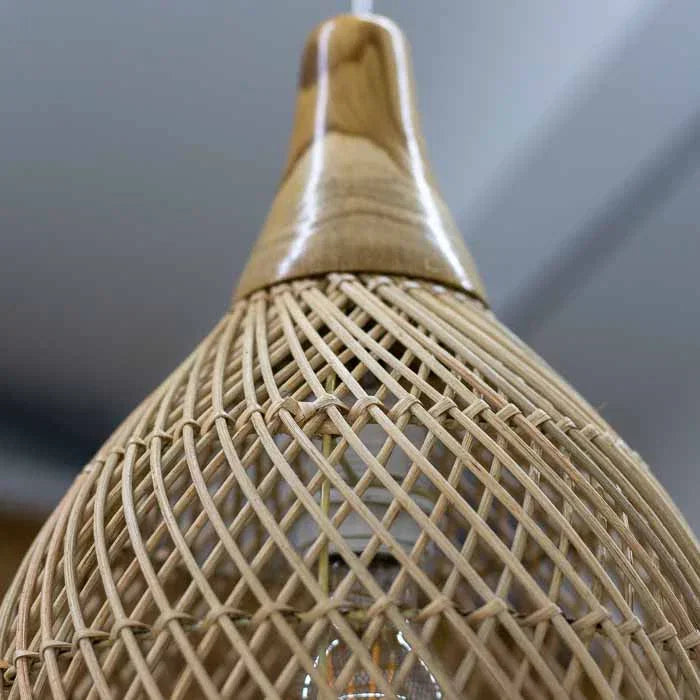Luminária pendente artesanal feita à mão em rattan natural, produzida em Bali com design leve.