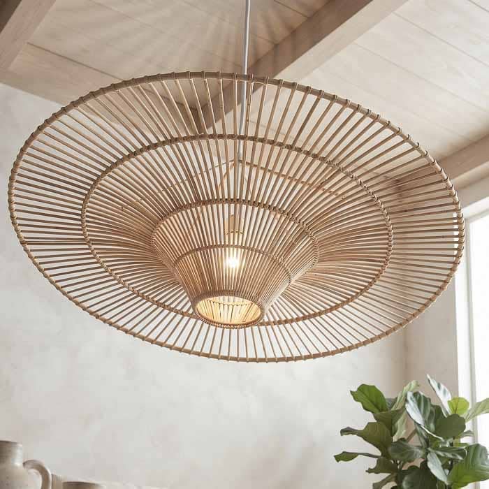 Cúpula pendente de teto em fibra natural de rattan com design vazado e cone central para iluminação cênica.