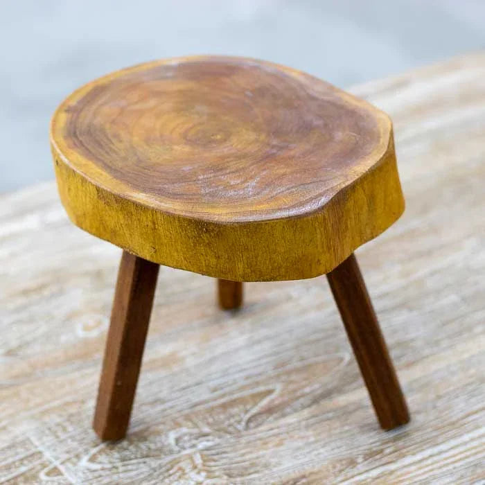 Banco orgânico de madeira com três pernas retas e assento curvo